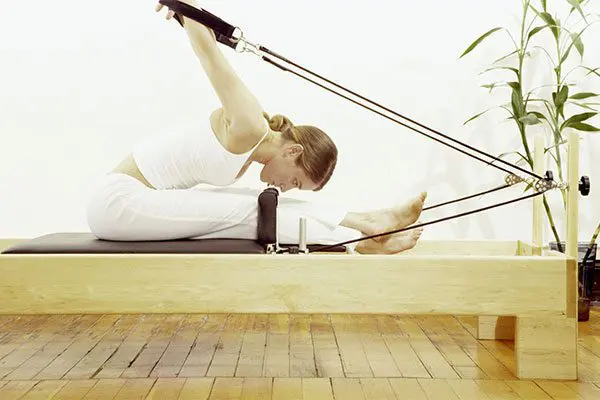 A woman is doing pilates on the floor