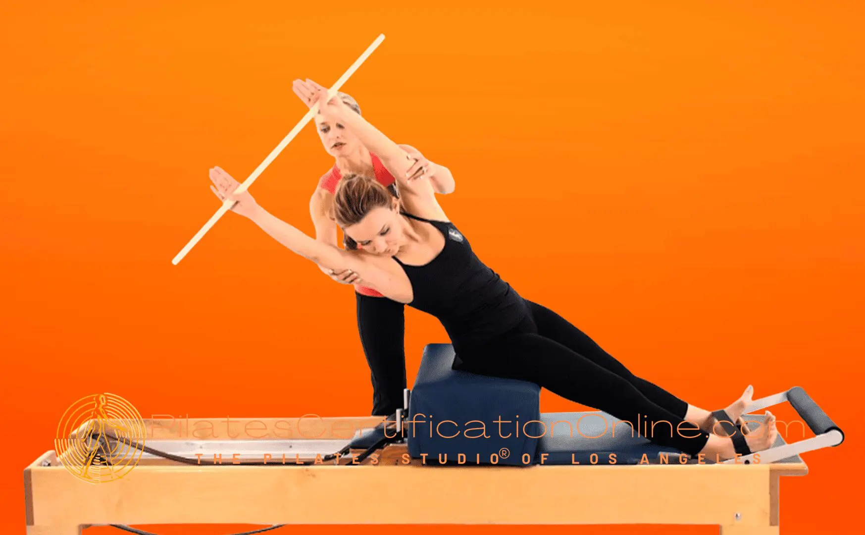 Two women are practicing yoga on a mat.