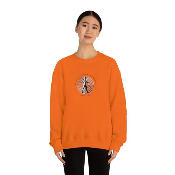 A woman wearing an orange sweatshirt with a basketball on it.