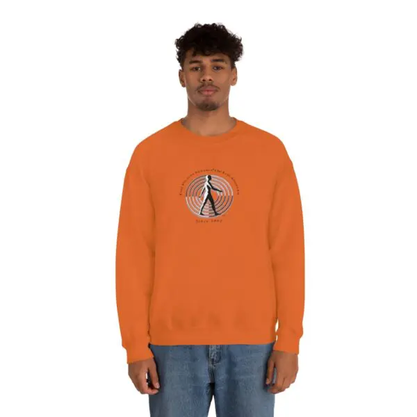 A man wearing an orange sweatshirt with a picture of a person.