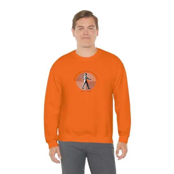 A man wearing an orange sweatshirt with a picture of a person.