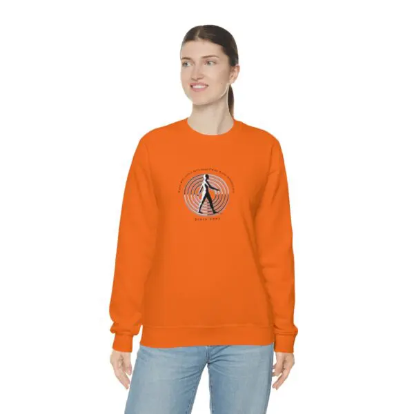 A woman wearing an orange sweatshirt with a picture of a person.