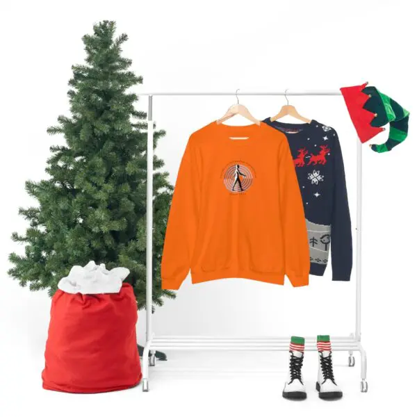 A christmas tree and clothes hanging on a rack.