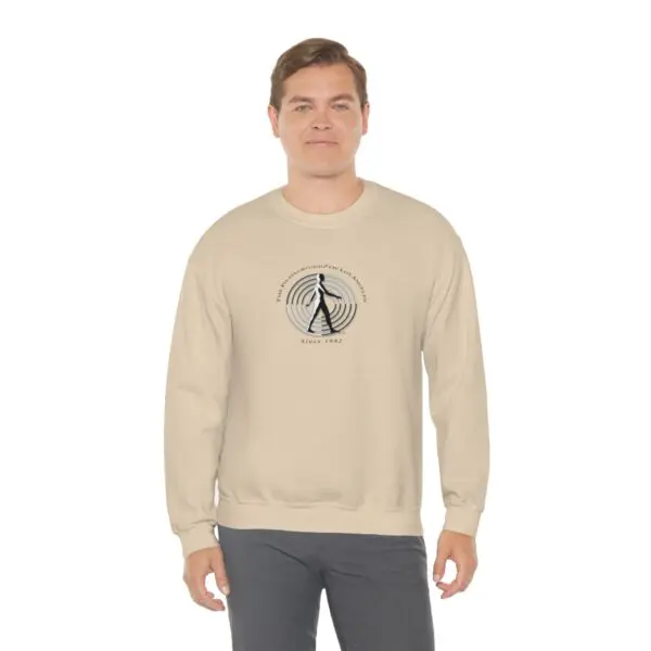 A man wearing a tan sweatshirt with an image of a tree.