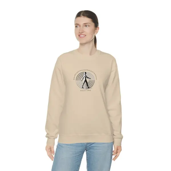 A woman wearing a tan sweatshirt with an image of a person walking.