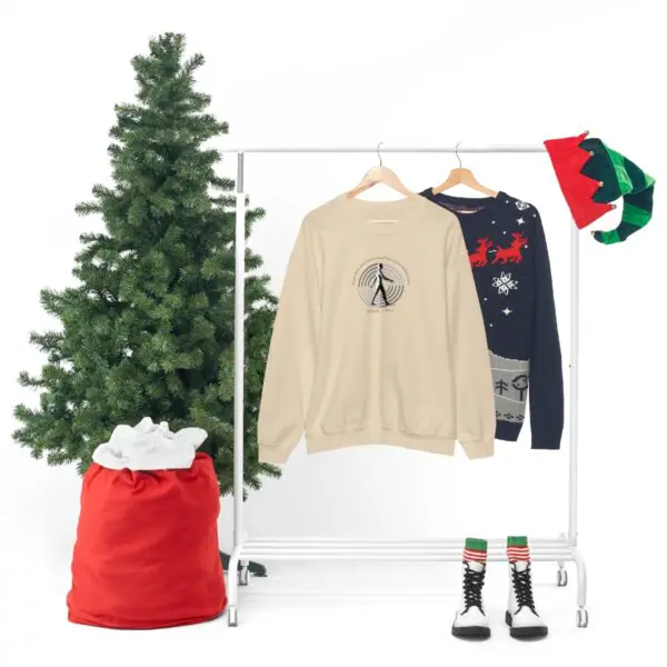 A christmas tree and clothes hanging on a rack.