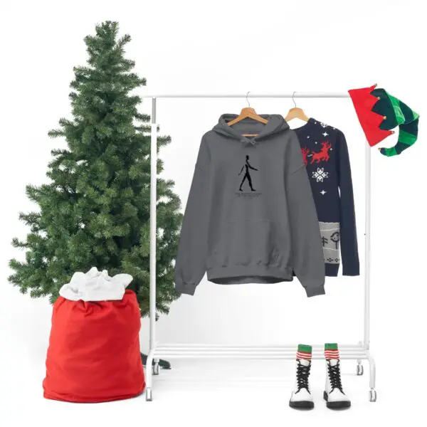 A christmas tree and clothes hanging on a rack.