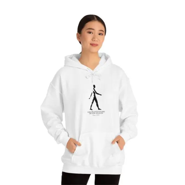 A woman wearing a white hoodie with a picture of a person walking.