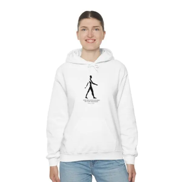 A woman wearing a white hoodie with an image of a person walking.