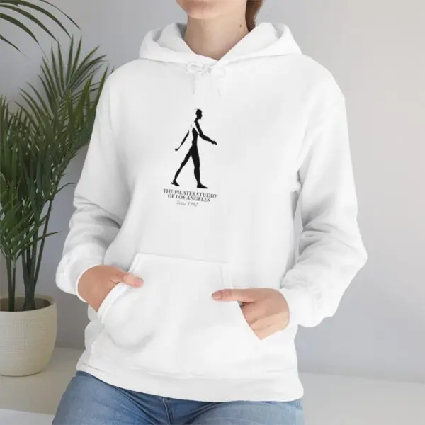 A woman is wearing a white hoodie with a drawing of a person walking.