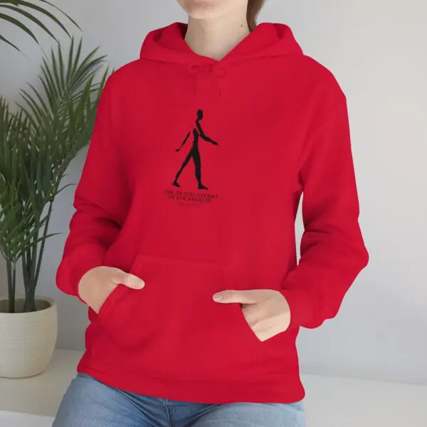 A person wearing a red hoodie with their hands in pockets.