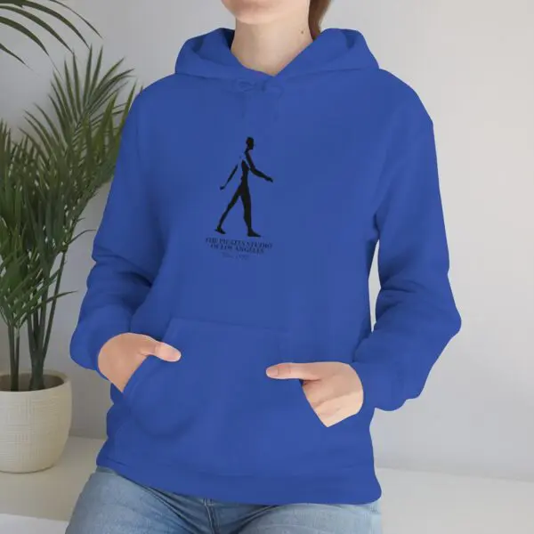 A person wearing a blue hoodie with a black image of a man walking.