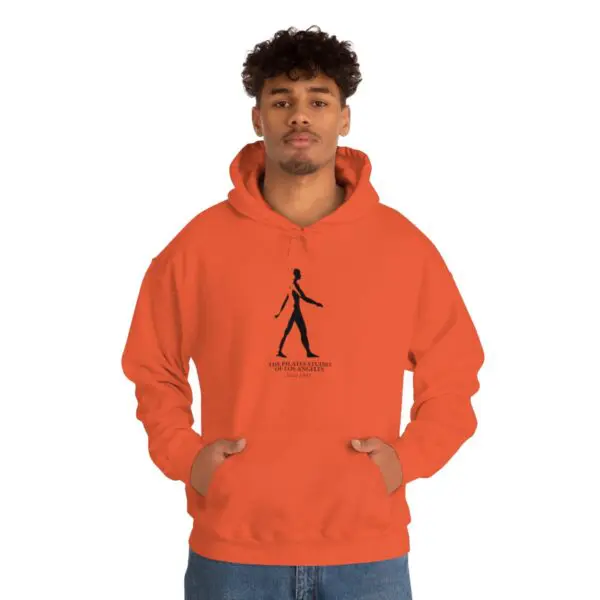 A man in an orange hoodie is standing up