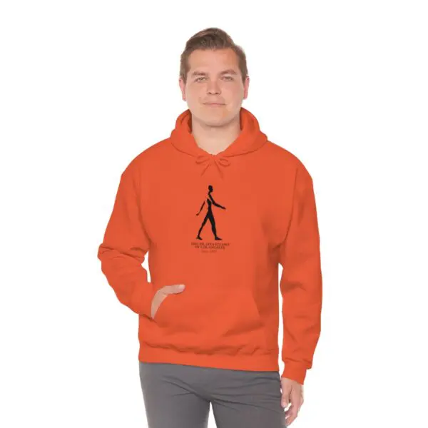 A man in an orange hoodie is standing up