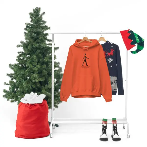 A christmas tree and clothes hanging on a rack.