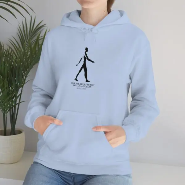 A person wearing a light blue hoodie with a drawing of a man walking.