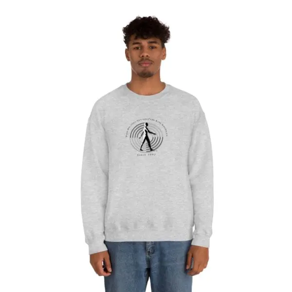 A man wearing a sweatshirt with an image of a person walking.