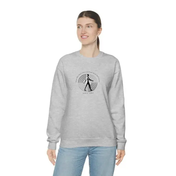 A woman wearing a sweatshirt with an image of a person walking.