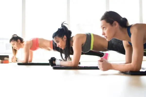 Two people are doing different exercises on a white table.